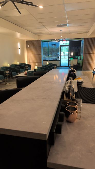 Modern bar interior with marble countertop and cozy seating area.