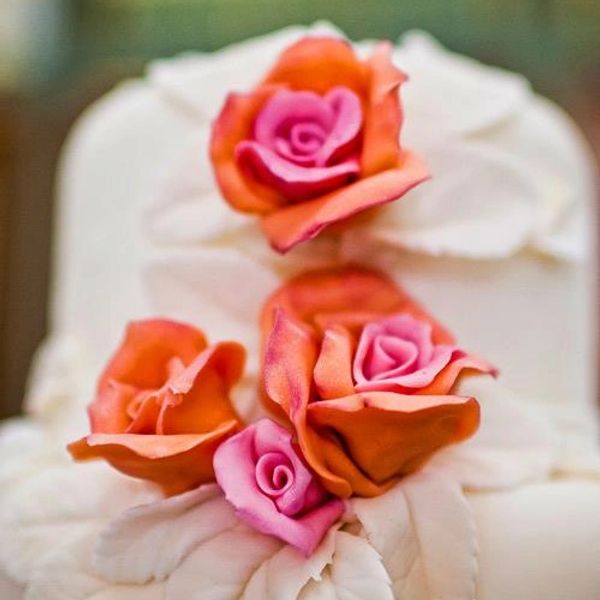white fondant wedding cake with orange roses