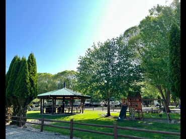 Gazebo playground in park with lush green grass