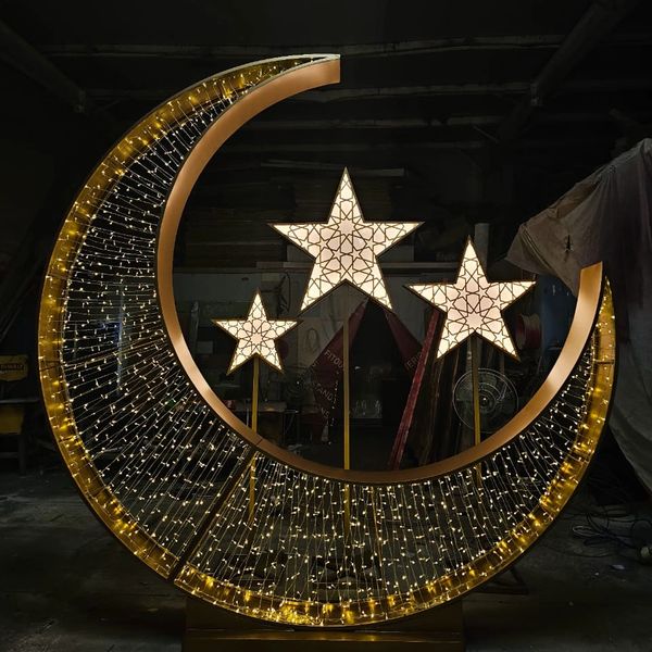 Illuminated crescent moon and stars decoration with intricate patterns.