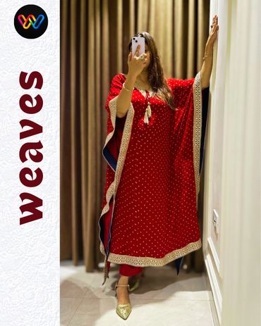 Woman in a red traditional dress taking a mirror selfie indoors.
