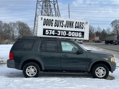 A car with a sign for Doug Buys Junk Cars in Mishawaka.