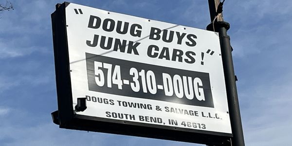 The sign for Doug Buys Junk Cars.