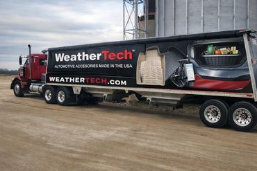 WeatherTech truck with automotive accessories advertisement on the trailer.