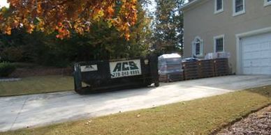Dumpster and materials in the driveway.