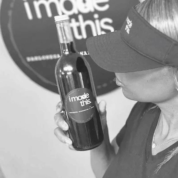 Person holding a bottle labeled "i made this".