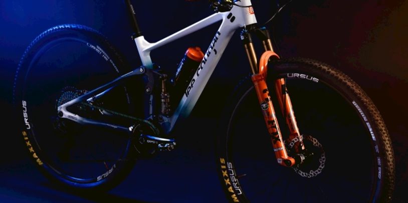 High-end mountain bike with orange shock fork and black and white frame.