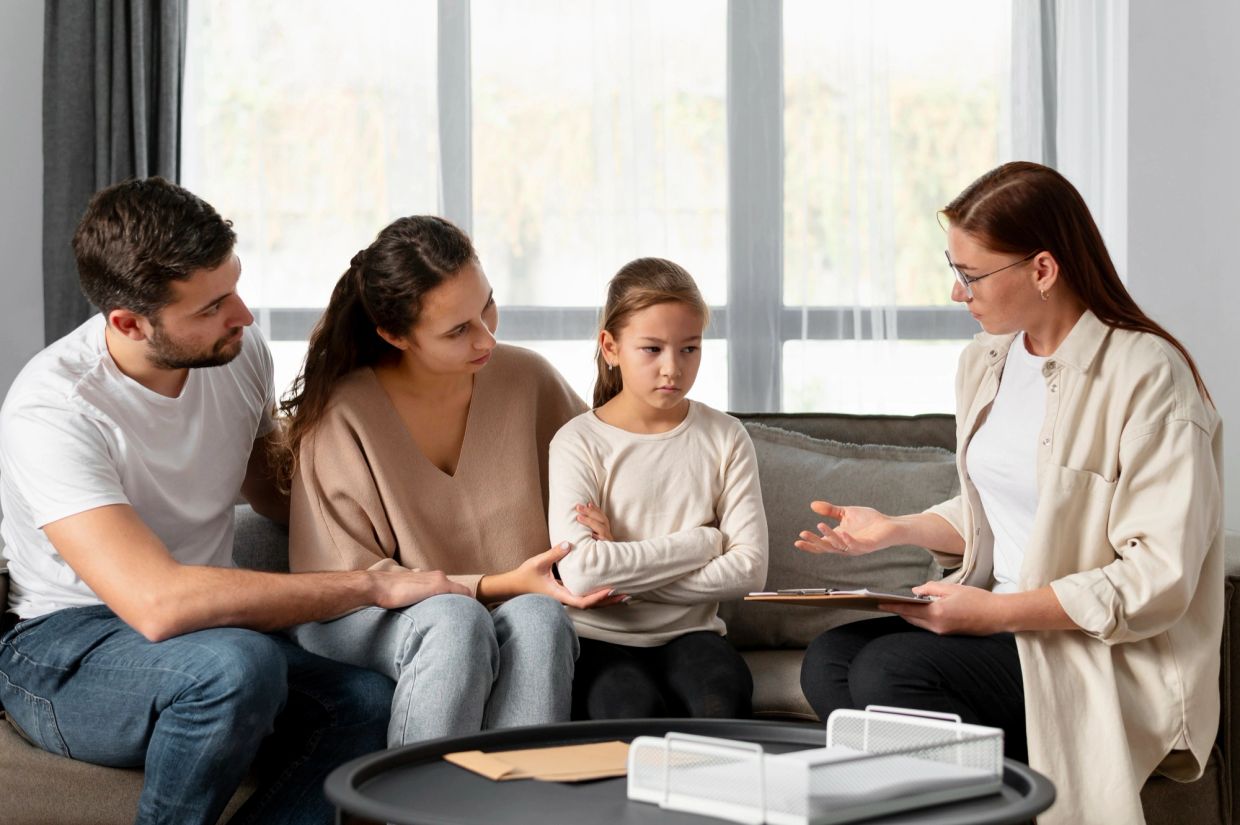 Family therapy session with a young girl and parents.
