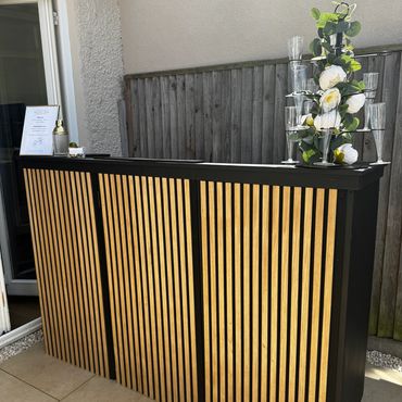 Modern wooden outdoor bar with floral decoration.