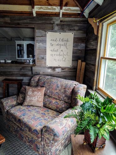 Cozy rustic cabin interior with patterned loveseat and welcoming decor.