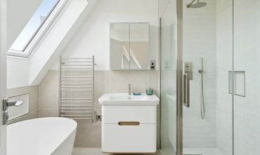 Modern bathroom with a bathtub, vanity, and glass shower enclosure.