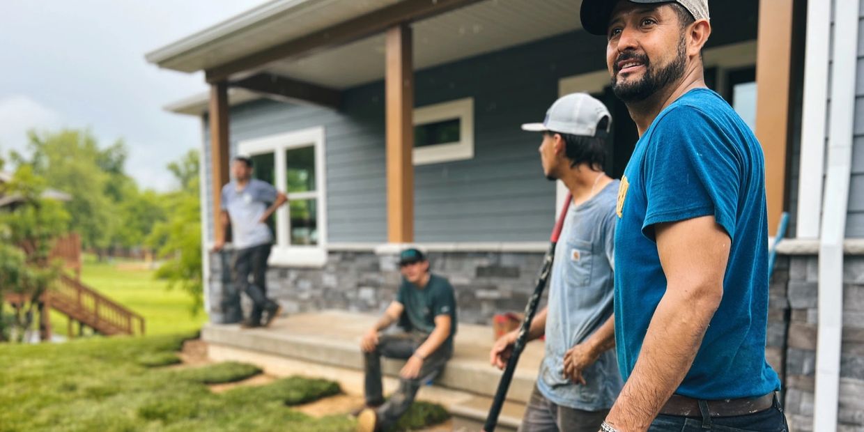 Group of workers taking a break outside a house under construction.