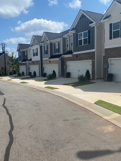 Driveways with green patches in front of garage doors in a residential area.