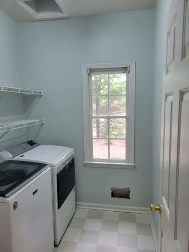 Bright laundry room with washer, dryer, and window.