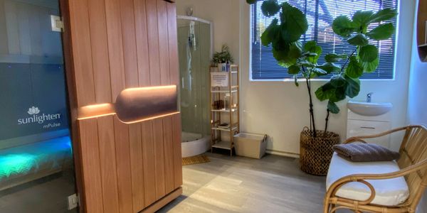 Modern wellness room with wooden sauna and plant.
