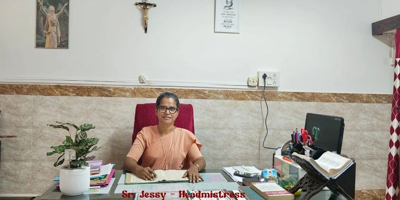 Woman seated at a desk in an office with religious decor.