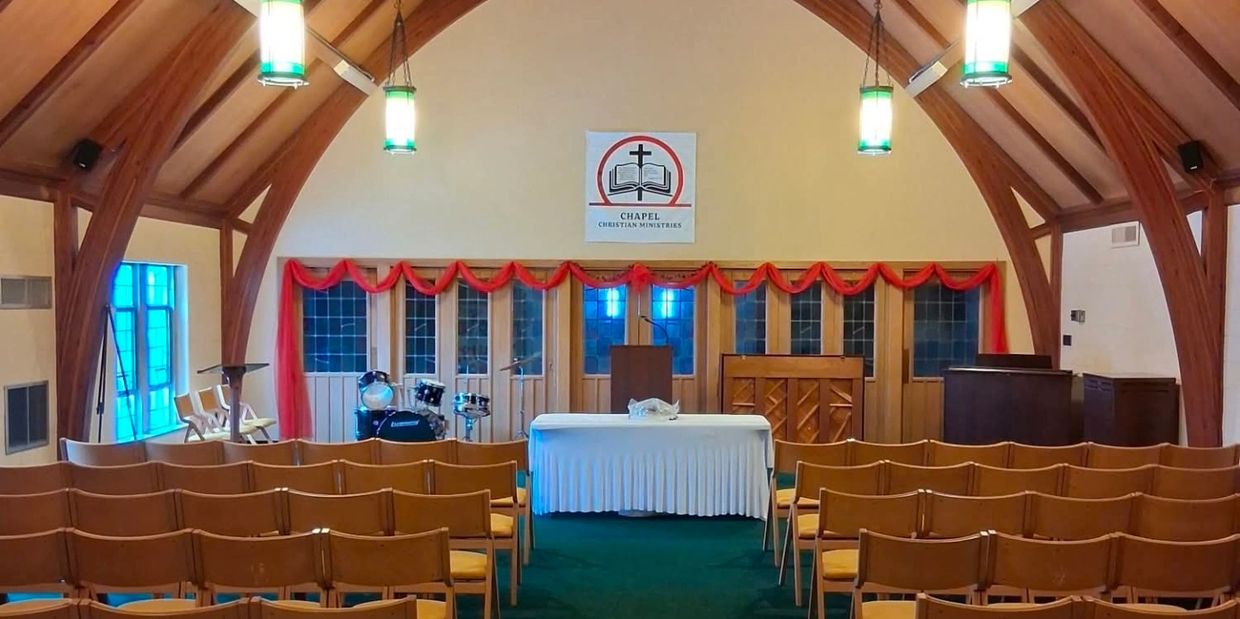 Interior of a small chapel with wooden beams and seating.