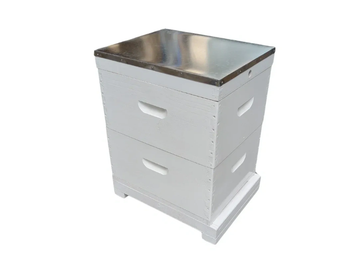 White wooden hive box with metal lid for beekeeping.