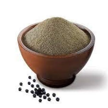 A bowl filled with ground black pepper and some black peppercorns beside it.