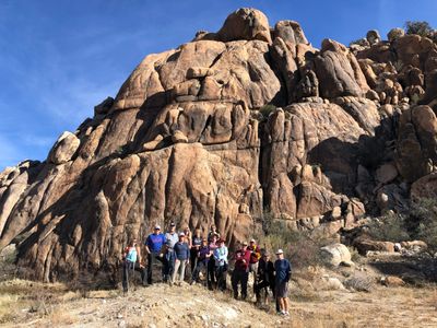 Large group of Pamela's Wellness tribe in front of beautiful rock formation, prior to a hike.