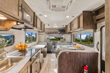 Interior of a modern RV with kitchen and seating area.