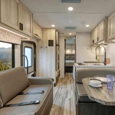 Interior of a modern motorhome with dining and seating area.
