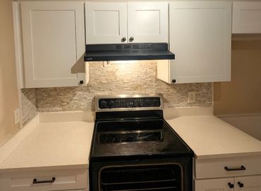Install new kitchen cabinets and range hood, venting to exterior