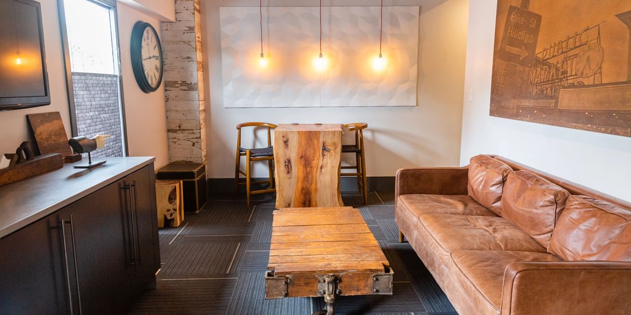 Cozy modern living room with leather sofa, wooden tables, and warm lighting.