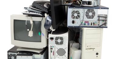 a pile of electronic waste like computer towers, monitors, speakers, etc