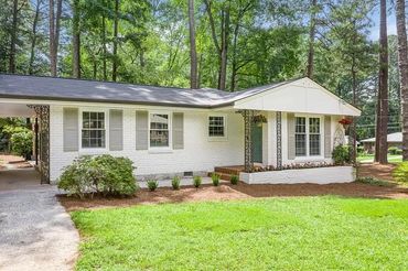 Modern luxury home with a lush garden nestled in a dense forest.