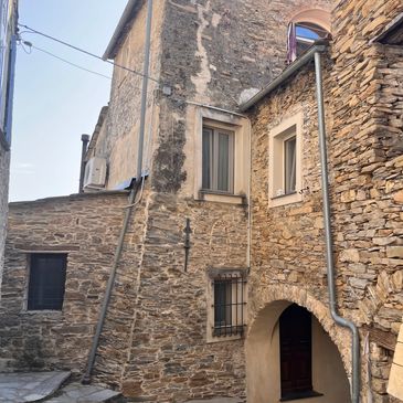 Stone buildings with narrow windows in a quaint alleyway.