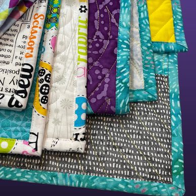 Stack of quilts showing binding services.