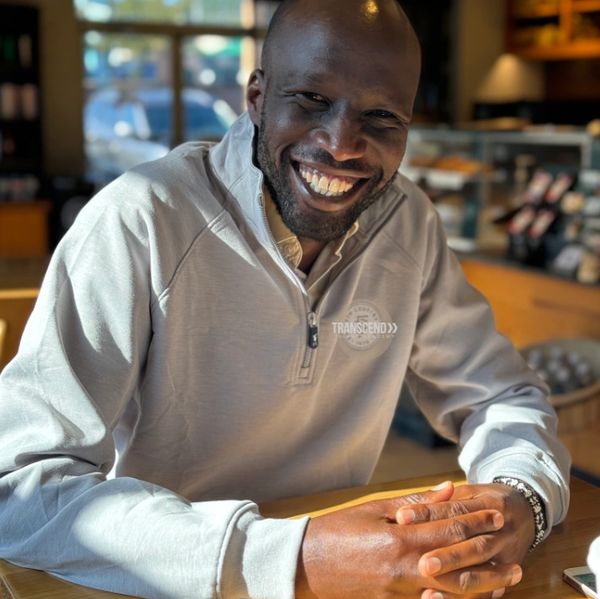Man smiling warmly at a cafe.