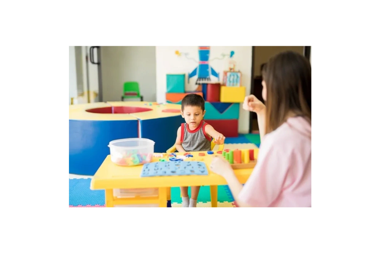 a little boy playing with an adult woman watching him