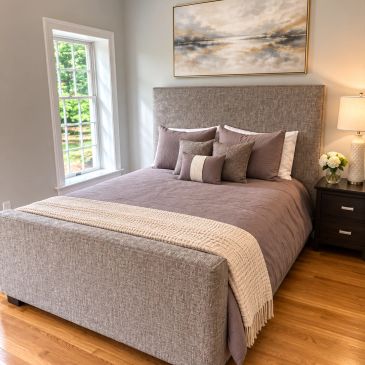 Cozy bedroom with a neatly made bed and neutral tones.