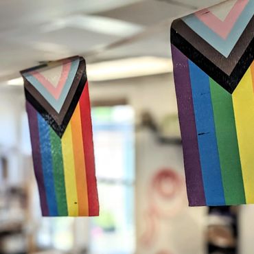 The inclusion pride flag hangs inside the studio