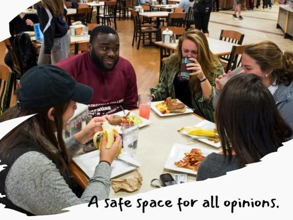 Group of friends eating together in a cafeteria, captioned 'A safe space for all opinions.'