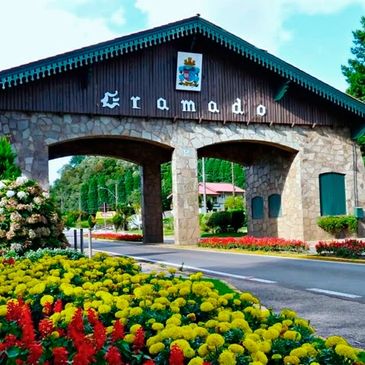 Entrance archway to Gramado adorned with flowers and greenery.