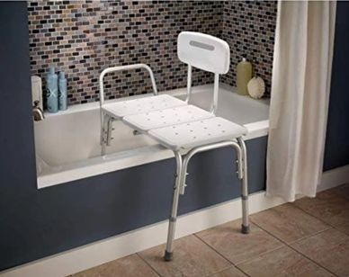 A white bath transfer bench with aluminum legs placed over a bathtub.