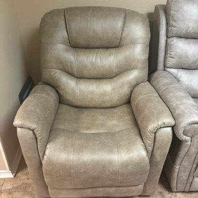 Beige leather recliner chair in a cozy room corner.