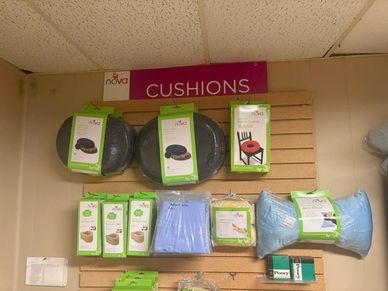 Display of various cushions and support products on a wall rack.