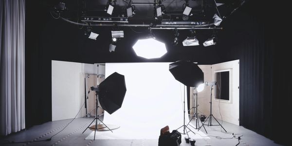 Professional photography studio setup with multiple lights and umbrellas.