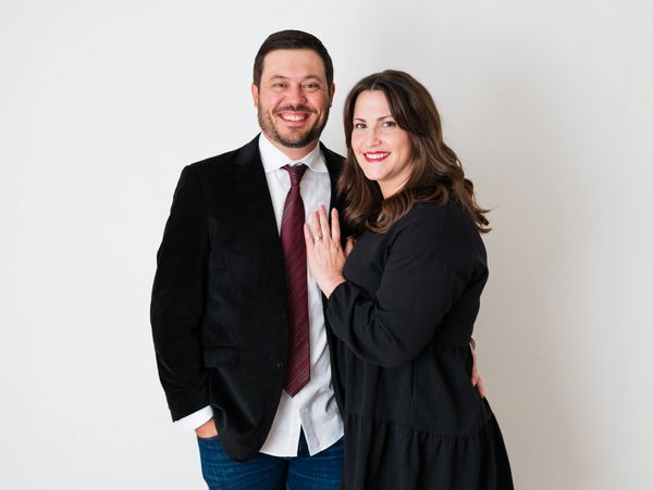 Smiling couple posing in semi-formal attire.