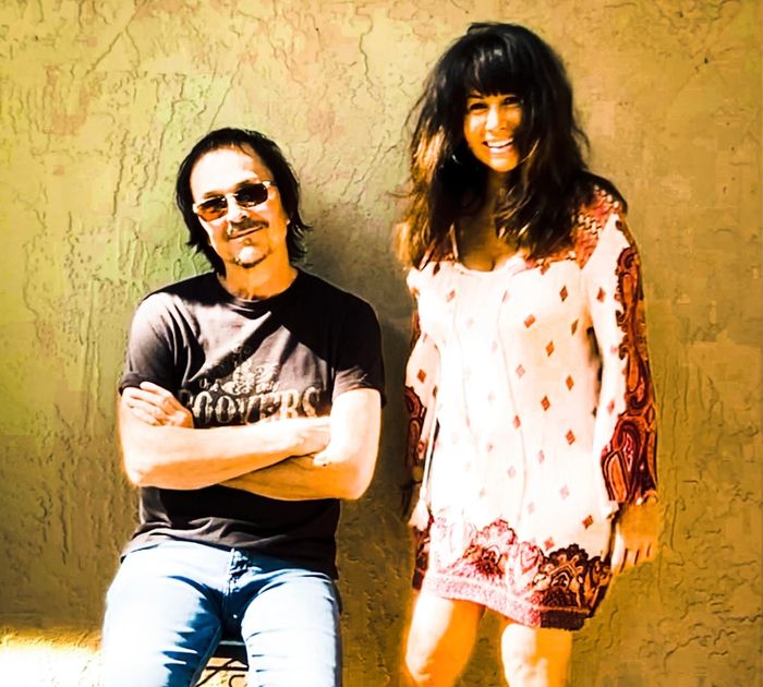 A colorful logo featuring two birds and a guitar with 'The Flying Stones' text.