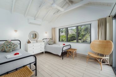 Bright bedroom with twin beds and large window.