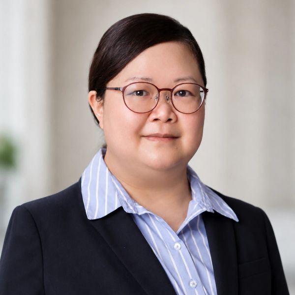 Professional portrait of a woman wearing glasses and a suit.