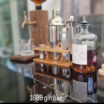 A close up of the gin bar showing a bottle of whiskey and a cocktail shaker kit.
