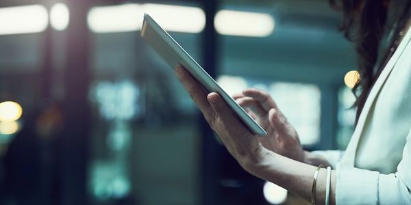 Person using a tablet with blurred background.