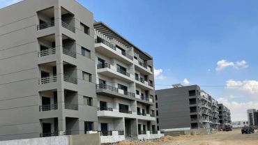 Modern apartment buildings under construction on a clear day.