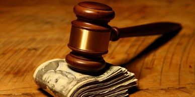 A gavel resting on a stack of dollar bills.